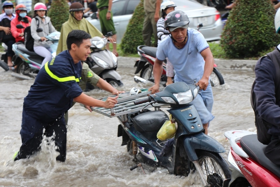 Công an còng lưng giúp người đi đường vượt biển nước - 7