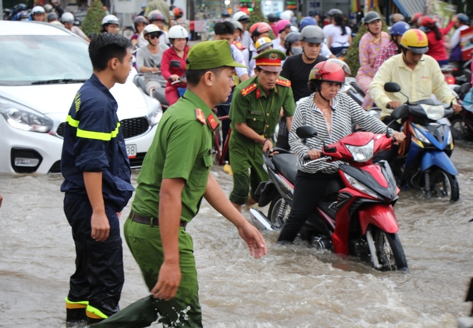 Công an còng lưng giúp người đi đường vượt biển nước - 2