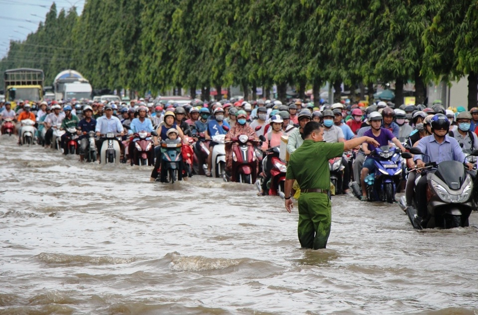 Công an còng lưng giúp người đi đường vượt biển nước - 1