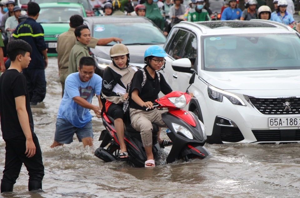 Công an còng lưng giúp người đi đường vượt biển nước - 12