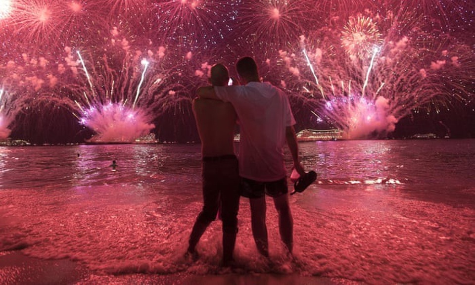 
Hai người đàn ông khoác vai nhau ngắm pháo hoa trên bờ biển Copacabana ở Rio de Janeiro, Brazil. (Ảnh: AP)
