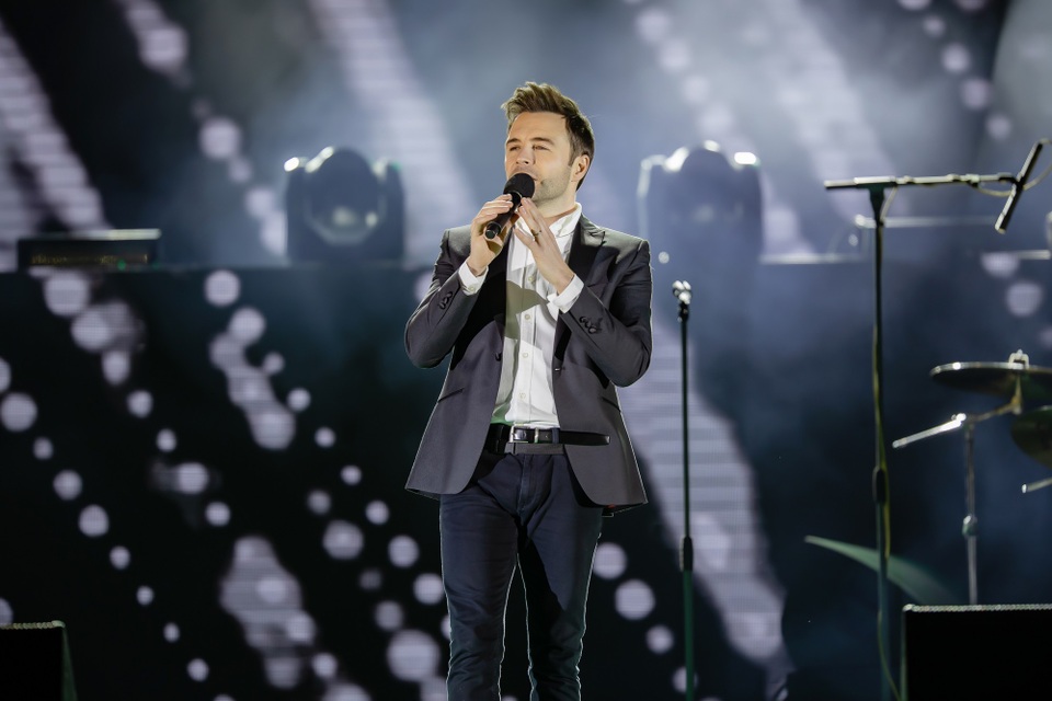 Nguyên Khang hạnh phúc bắt tay trưởng nhóm Westlife mừng năm mới tại Việt Nam - 4 Shane Filan chia sẻ cảm xúc khi anh quay lại Việt Nam lần thứ hai thật hạnh phúc, Shane Filan đã đi xuống tận khu vực khán giả để hát giao lưu. Hàng ngàn khán giả đã cầm điện thoại tạo nên bầu trời đầy sao khi anh hát. Shane hát live tốt, anh giao lưu ngắn gọn và mời khán giả hát cùng ca khúc My love đình đám của Westlife.