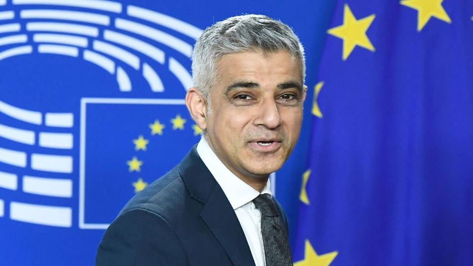 
Thị trưởng London Sadiq Khan đứng trước nền cờ EU (Ảnh: Sky)
