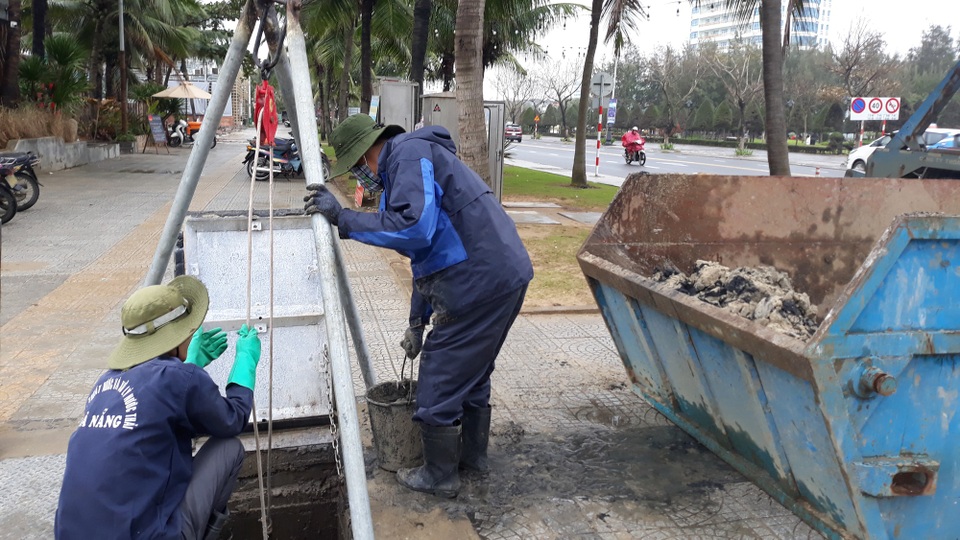 Bờ biển Đà Nẵng sạt lở nghiêm trọng - 8
Công nhân múc cát từ cửa xả thải do sóng biển đánh vào.