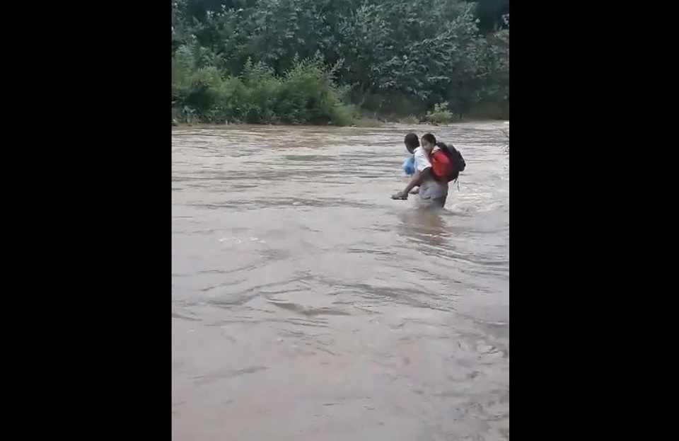 Người cha cõng con băng qua dòng nước xiết để đến trường Thót tim cảnh cha cõng con vượt dòng nước xiết đến trường