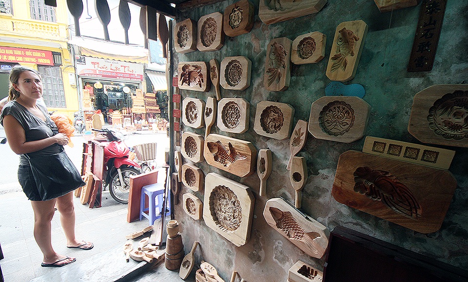 Nhiều khách nước ngoài tỏ ra khá thích thú ngắm nhìn những mẫu khuôn với hoa văn tinh xảo ở cửa hàng ông Quang