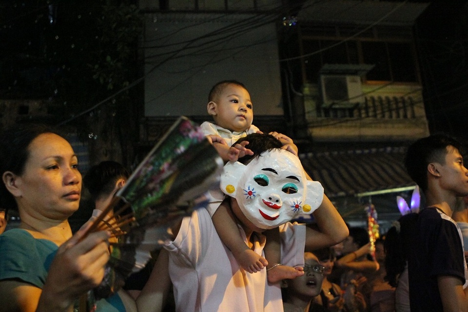 Nhiều em nhỏ được bố mẹ kiệu trên lưng để tránh xô đẩy