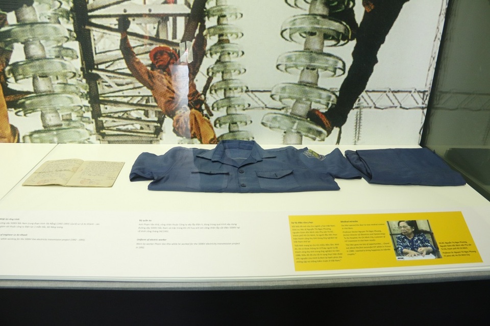 
Là Tổng Bí Thư đầu tiên của thời kỳ Đổi Mới, ở thời điểm quyết định vận mệnh sống còn của đất nước lúc ấy, ông Nguyễn Văn Linh hiện lên như một kiến trúc sư đầy tài năng, tâm huyết với bản lĩnh mở đường, tìm lối. Tổng Bí Thư Nguyễn Văn Linh cũng được xem là người dẫn đầu cho cuộc thử nghiệm Đổi mới đi đến thành công. Nhờ đó, nhiều doanh nghiệp đã mạnh dạn vượt ra khỏi cách làm ăn cũ, bước đầu gặt hái thành công. Trong ảnh là trang phục của một công nhân nhà máy điện giai đoạn này. Đây cũng là hình ảnh tượng trưng cho sự thay đổi giữa cách làm ăn cũ và mới.
