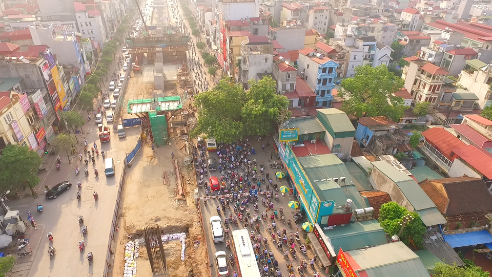 
Lòng đường bị rào chắn, lô cốt thu hẹp khoảng 2/3 diện tích, nhiều đoạn hình thành những nút thắt cổ chai gây ùn ứ giao thông nghiêm trọng vào giờ cao điểm. Trong ảnh, một đoạn đường ở khu vực Cầu Diễn bất ngờ bị thu hẹp để thi công nhà ga trên cao. Các phương tiện di chuyển theo hướng từ Cầu Diễn vào trung tâm thành phố bị dồn ứ lại tại nhiều điểm.
