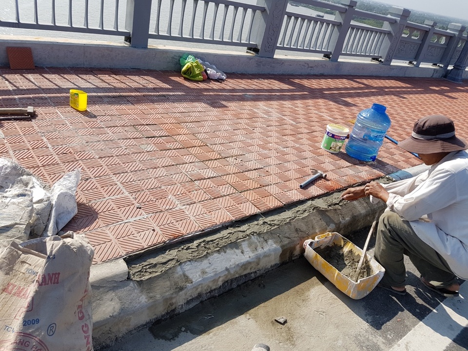 Cầu đúc hẫng lớn nhất Việt Nam vừa được sử dụng đã bong tróc - 4 Công nhân đang tiến hành lát lại vỉa hè trong ngày 19/10