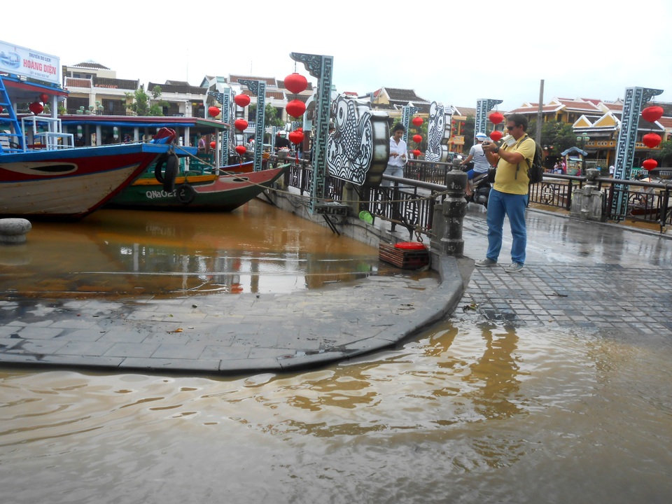 Du khách chụp ảnh nước dâng tại cầu An Hội