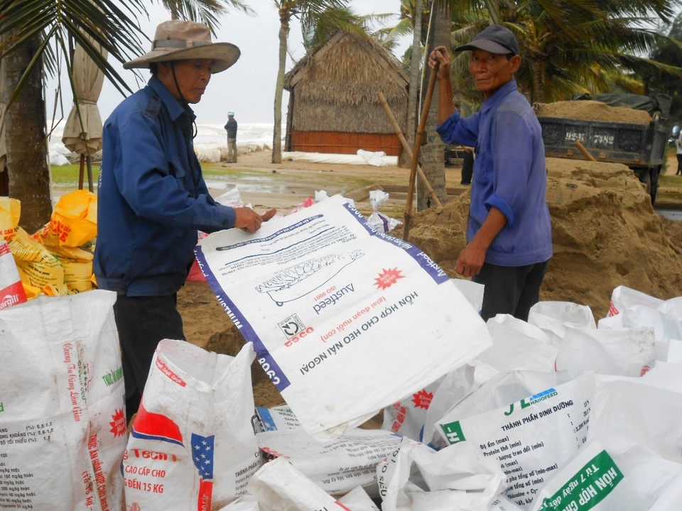 Liên tục xúc cát đổ vào bao để chắn sóng