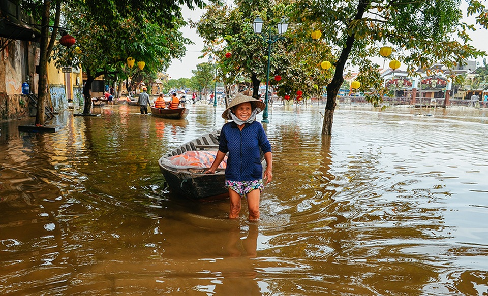 Một người chèo ghe cười tươi đón khách lên ghe