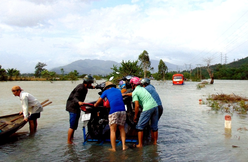 Người dân khiêng xe máy qua vùng ngập lụt ở xã Đại Lãnh, huyện Đại Lộc