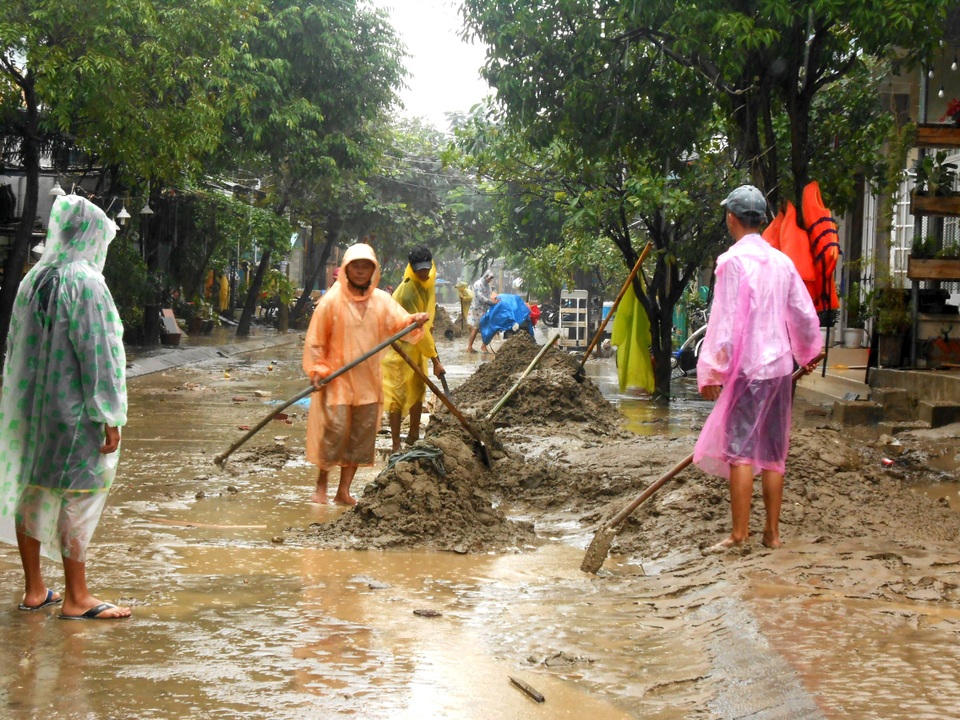 Bùn non bám dày đặc trên mặt đường, người dân và công nhân vệ sinh phải rất vất vả để dọn dẹp