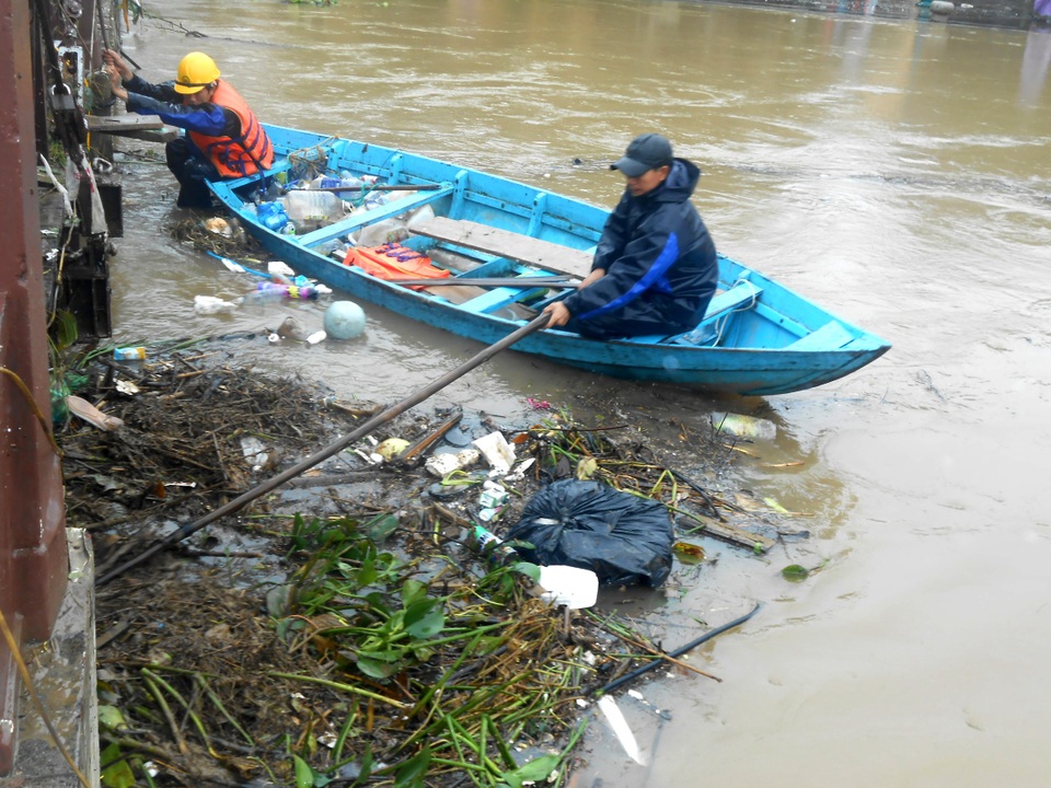 Công nhân phải rất vất vả để dọn lượng rác khổng lồ do lũ đem tới