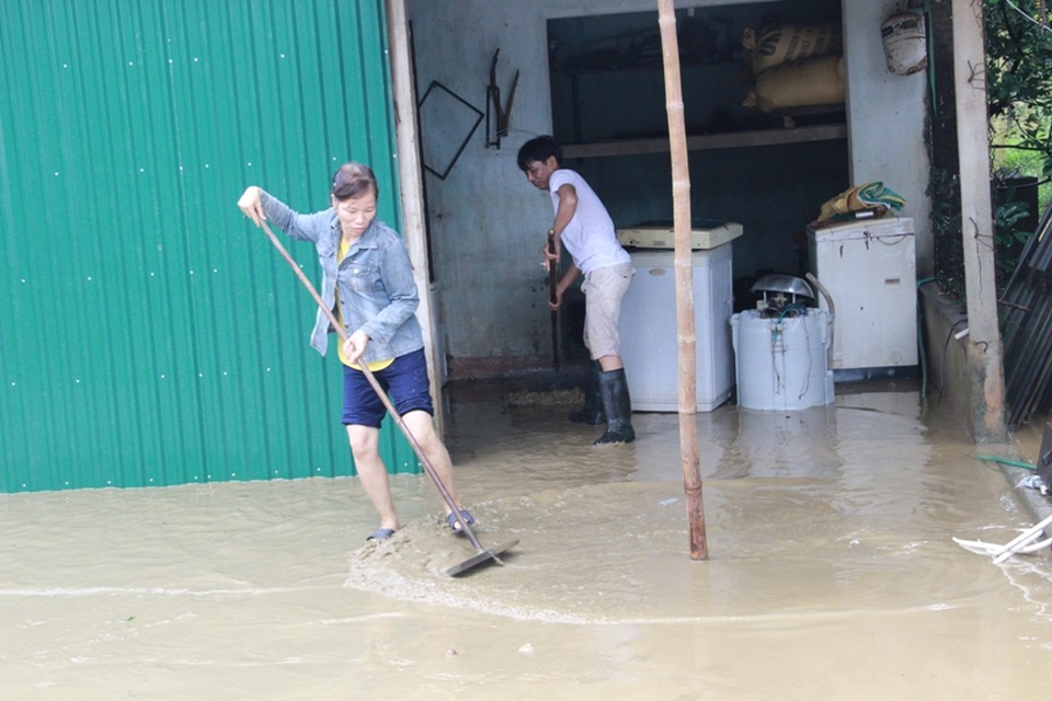 Người dân xã Vĩnh Lâm dọn bùn do lũ cuốn vào nhà