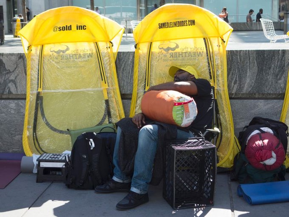 Một người đàn ông ngủ gục khi đang xếp hàng trước Apple store tại phố Fifth Avenue, New York vài giờ trước khi ra mắt iPhone 7