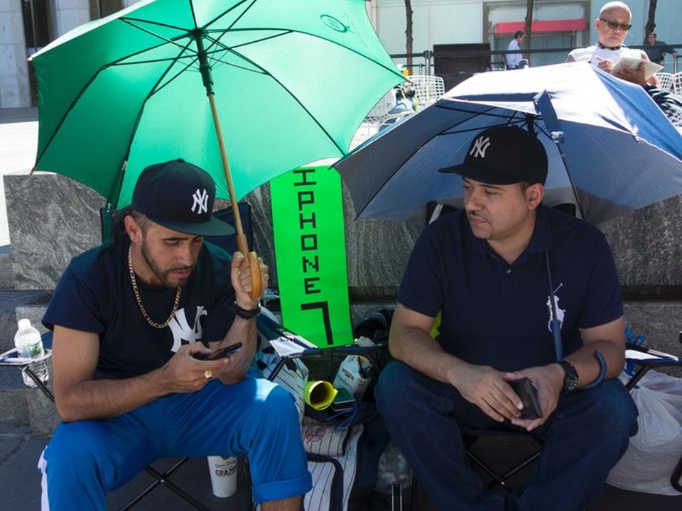 Những người chờ iPhone 7 thậm chí phải dùng ô trước cái nắng khá gay gắt tại New York, Mỹ trong ngày mở bán.