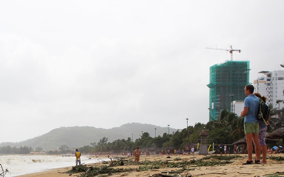 Du khách thư giãn trên bãi biển mùa sóng lớn