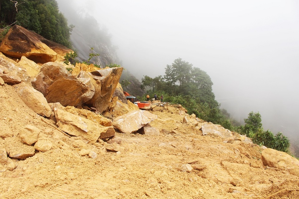 Tuyến đường bị đất đá chắn ngang khiến giao thông tê liệt trong nhiều ngày qua. Tại điểm Km56+190, đất đá sạt trượt dài hàng chục mét, cao hơn 10m khiến việc khoan cắt gặp nhiều khó khăn