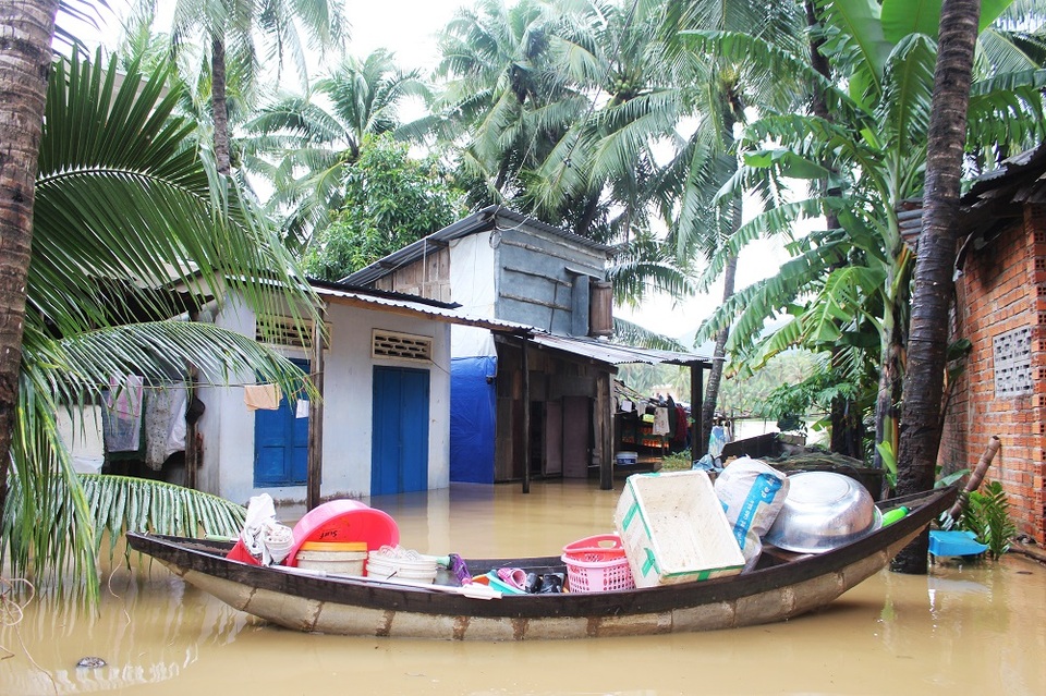 Nhà dân ở phường Ngọc Hiệp (TP Nha Trang) bị ngập sâu và phải chất đồ lên một con thuyền để chạy lũ