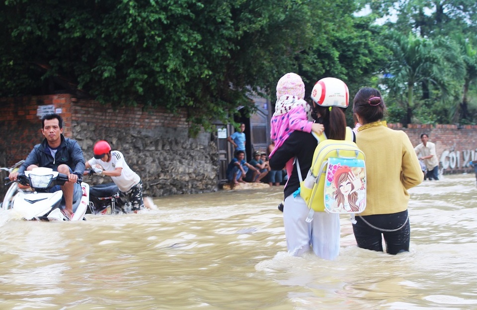 
Một phụ nữ Nha Trang bế con vượt lũ về nhà
