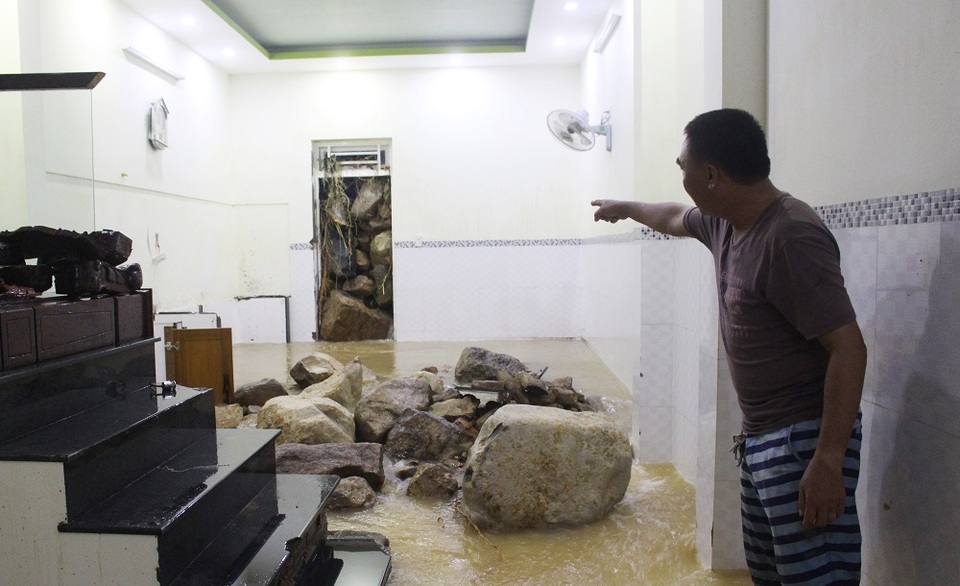 
Căn nhà của chị Phạm Thị Út Hạnh (38 tuổi) bị đá xé cửa lăn vào nhà khiến 3 mẹ con chị sợ hãi suốt đêm. Theo chị Hạnh, nhà chị có 3 tầng hoàn thành vào năm ngoái, với kinh phí xây dựng hơn 1 tỷ đồng. 3 mẹ con tôi ngủ trên tầng 2 thì nghe một tiếng rầm như bom nổ. Chạy xuống nhà dưới thì một cảnh tượng kinh hoàng, đất đá lăn vào nhà, đồ đạc bị cuốn trôi ra đường, chị Hạnh kinh hãi kể.
