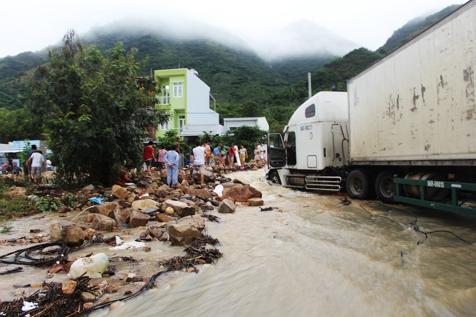 Một xe container bị mắc kẹt giữa dòng nước và đất đá sau khi kênh thoát lũ Đường Đệ (TP Nha Trang) bị vỡ do mưa lớn