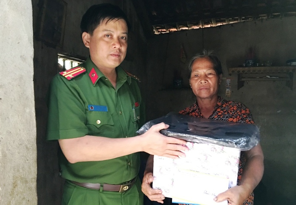 Trung tá Trần Hùng Vương - Trưởng Công an huyện Như Thanh trao quà hỗ trợ của Công an huyện tới gia đình em Trúc.
