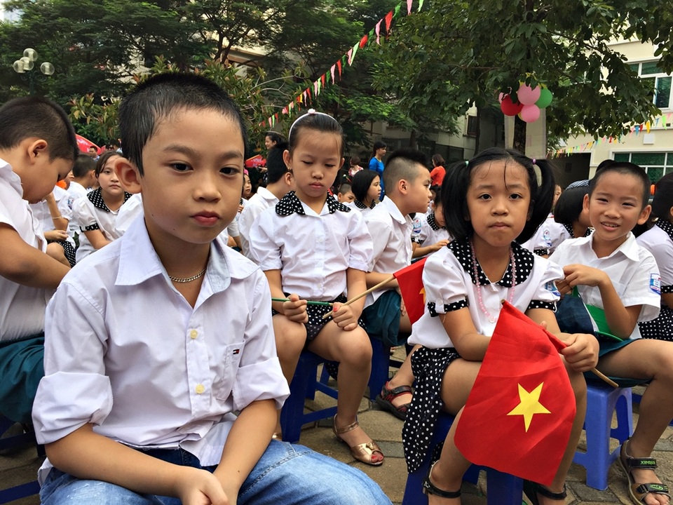 Các em nâng niu lá cờ Tổ quốc trên tay.