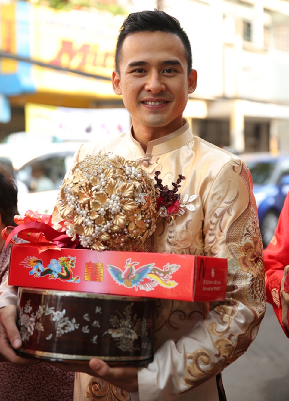 Còn thiết kế áo dài của Lương Thế Thành có phom dáng vest cách tân, hiện đại. Phía trên màu đồng đậm, phần dưới màu áo trùng với áo cô dâu, có sự chuyển biến về màu sắc giống ombre.