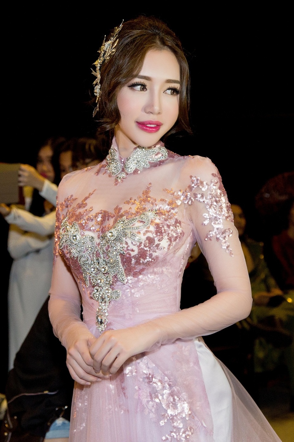 Trong chương trình, bà mẹ hai con diện mẫu áo dài xuyên thấu do NTK đo ni đóng giày cho cô. Thiết kế áo cưới Elly Trần diện nhấn mạnh ở phần ngực áo đính kết đá quý thành một trái tim to bản. Phần chiết eo nhẹ nhàng đặc trưng của áo dài nguyên bản tôn lên vòng hai của bà mẹ hai con.