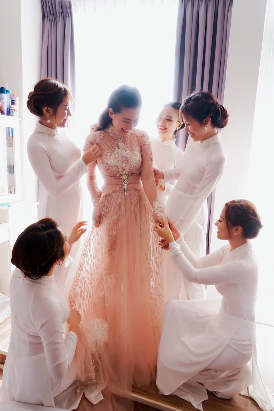 Nếu áo dài truyền thống thường gắn liền với vẻ cổ điển và tay áo raglan thì NTK vận dụng cách cắt tay liền tương tự phom dáng dạ hội để tạo nên chiếc áo của Ngọc Lan. Nhờ đó, bộ trang phục vừa mang nét truyền thống, vừa hiện đại, phù hợp chung với chủ đề trang trí của buổi tiệc.