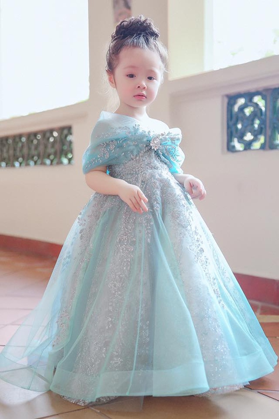 Cadie Mộc Trà “gây thương nhớ” khi hóa thành "công chúa Lọ Lem" - 6 Trong bộ ảnh mới chia sẻ, Cadie hóa thành một nàng công chúa Lọ Lem với chiếc váy xanh trong suốt đính ánh kim lấp lánh. Thiết kế nổi bật với viên đá đính ở trung tâm của phần vai trễ cách điệu như một chiếc nơ. Bộ váy phảng phất phong cách các mẫu váy mà Elly Trần thường mặc trong các sự kiện trước đây.