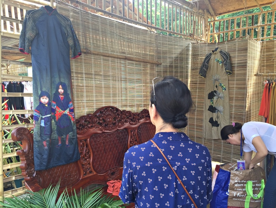 Một khách tham quan thích thú quan sát mẫu áo dài lấy cảm hứng từ vẻ ngây thơ hồn nhiên của trẻ em dân tộc thiểu số - một thiết kế của NTK Vũ Việt Hà.