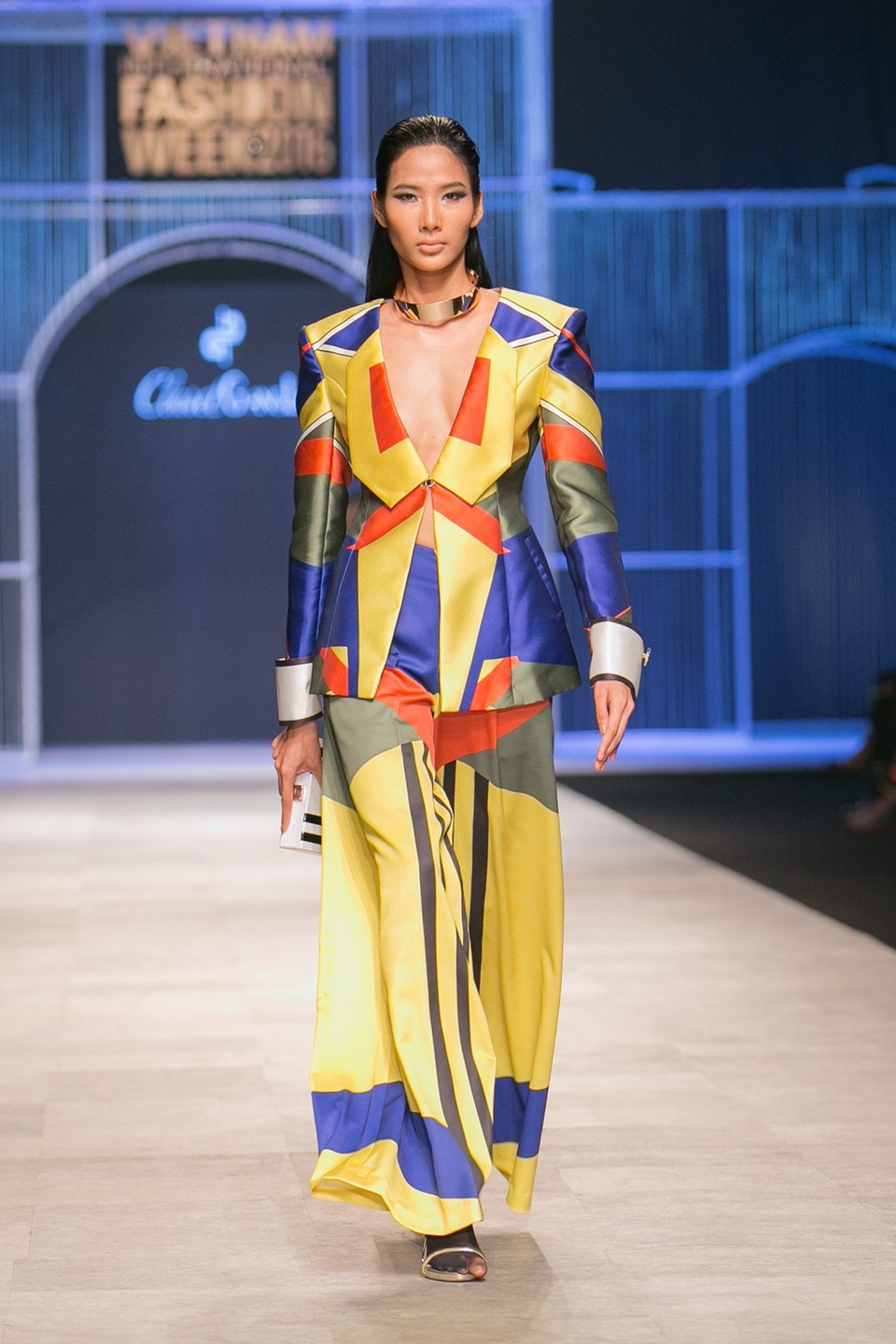 Ở vị trí vedette, Quán quân Next Top mùa thứ hai thể hiện thần thái tự tin, đầy kinh nghiệm. Hoàng Thùy bước đi tự tin với phong cách pop-art hiện lên sắc nét qua những khối màu tông cam, xanh dương làm chủ đạo. Xen kẽ với chúng là gam đen, trắng, vàng và đỏ rượu - cuộc chơi màu sắc như những bức tranh.