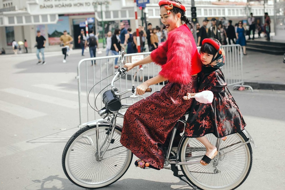 Người đẹp chọn xe đạp là phương tiện di chuyển đến góp mặt tại sân chơi street style này. Cô còn chở đằng sau một mẫu nhí vô cùng đáng yêu.