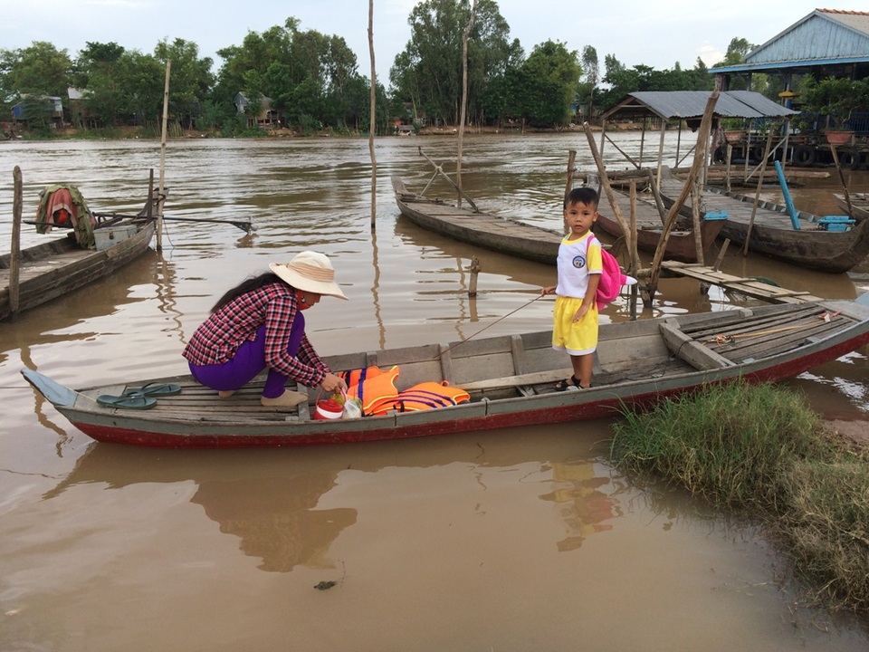Hàng trăm học sinh Việt Kiều vẫn lắc lư qua sông học chữ bằng xuồng nhỏ - 2 Nhiều phụ huynh không an tâm cho con đi đò ngang nên dùng xuồng nhỏ, trang bị áo pháo rồi đưa các đón các cháu qua sông mỗi ngày.