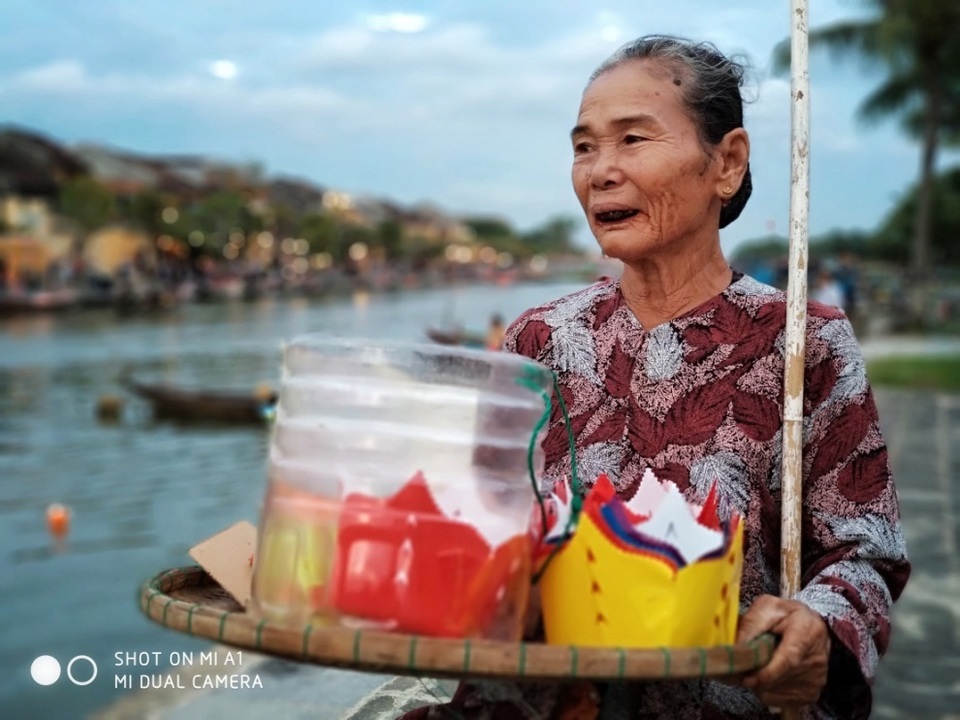 
Hoa đăng làm bằng giấy đủ màu sắc, được xếp gọn gàng trên chiếc mẹt của các cụ già - những chiếc đèn sắp khiến sông Hoài lung linh, khiến dòng trôi như lững lờ về quá khứ, và như thế chính những cụ già phố Hội cũng là những chiếc hoa đăng đã thắp sáng cho phố cổ.
