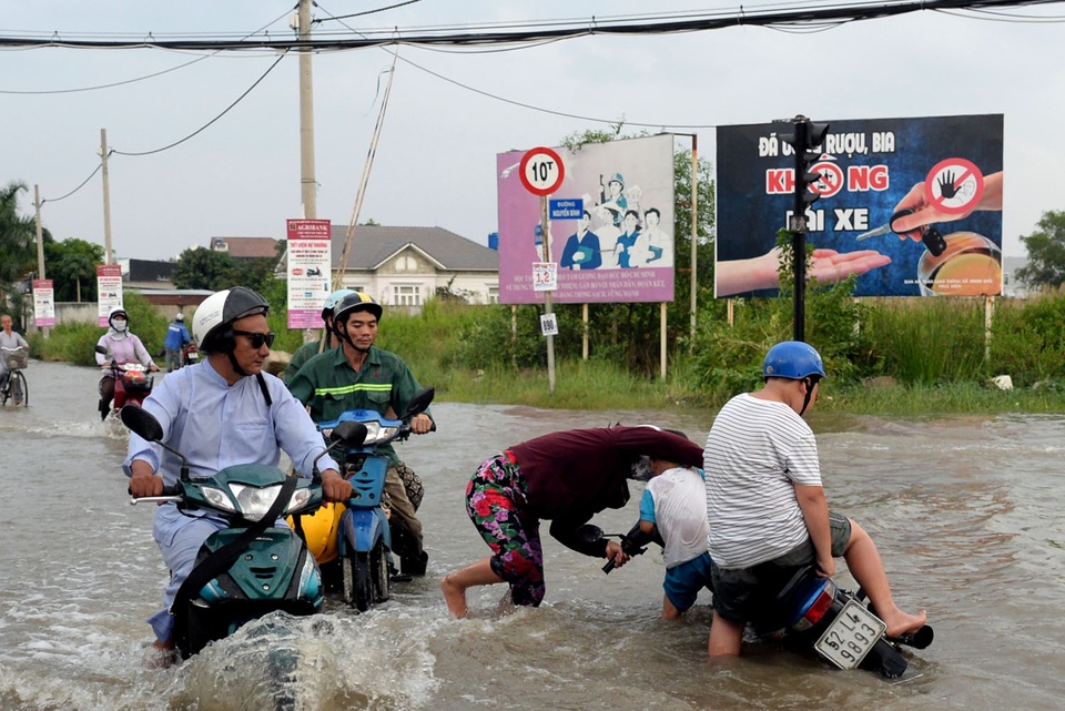 TP HCM: Triều cường dâng cao, nhiều người ngã sõng soài trong dòng nước - 2 Người phụ nữ loạng choạng tay lái té cả xe xuống nước.
