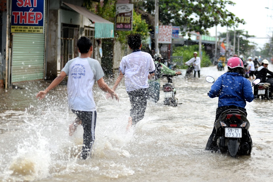 TP HCM: Triều cường dâng cao, nhiều người ngã sõng soài trong dòng nước - 9
Những học sinh đi học về tranh thủ đùa nghịch làm nước bắn tung tóe.