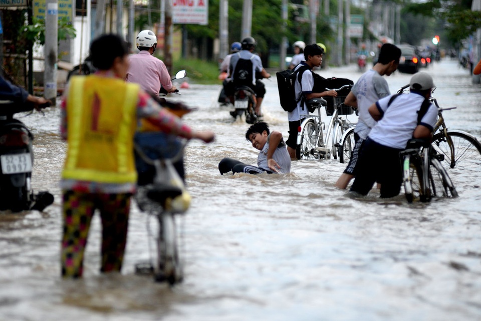 TP HCM: Triều cường dâng cao, nhiều người ngã sõng soài trong dòng nước - 1 Một em học sinh trung học té ngã khi đi học về ngang qua đoạn đường Lê Văn Lương, xã Nhơn Đức, huyện Nhà Bè.