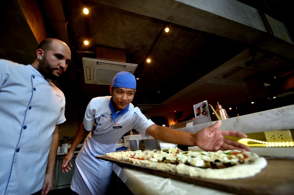 Sau phần tung hứng, bột sẽ được trải lên thớt nướng và trang trí.