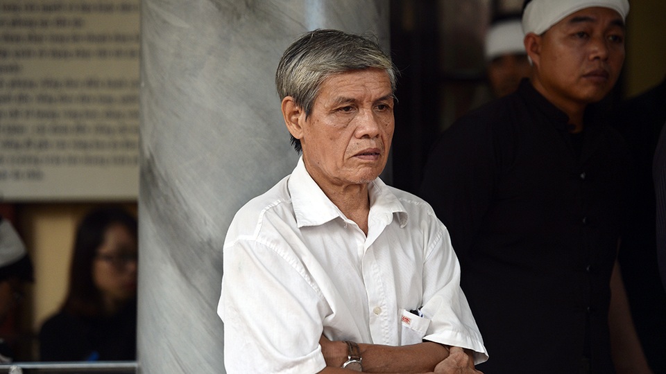 Một người quen của nam nghệ sĩ thẫn thờ nhìn theo đoàn xe tang.