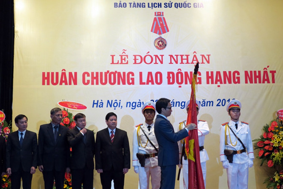 Bảo tàng Lịch sử Quốc gia đón nhận Huân chương Lao động hạng Nhất - 1 Phó Thủ tướng Chính phủ Vũ Đức Đam gắn Huân chương Lao động hạng Nhất lên lá cờ truyền thống của Bảo tàng Lịch sử Quốc gia. Ảnh: Hoàng Nguyên.