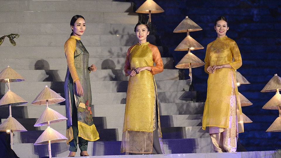 Dàn người mẫu khoe nét duyên dáng trong tà áo dài bên những chồng nón lá.