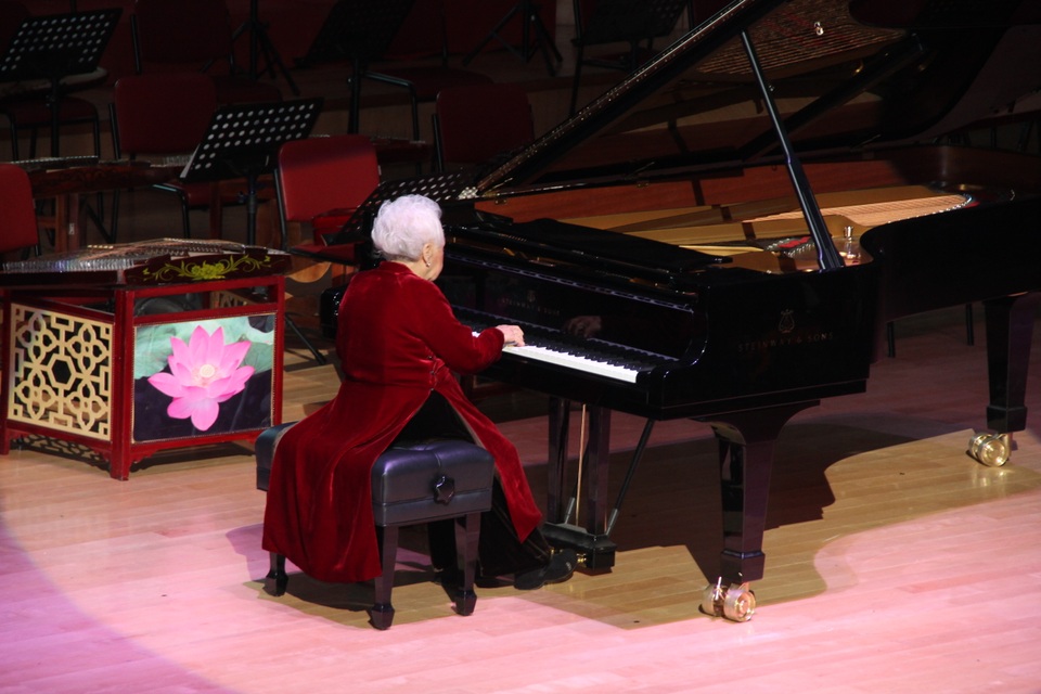 NSND Thái Thị Liên diện bộ áo dài nhung màu đỏ để biểu diễn piano khai mạc lễ kỷ niệm 60 năm ngày thành lập Học viện Âm nhạc.