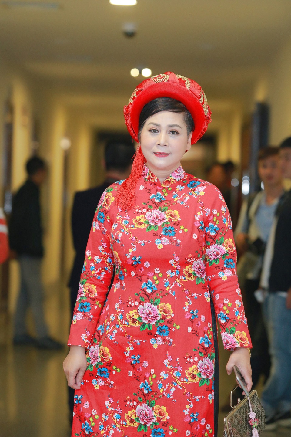 NSƯT Minh Hằng diện bộ áo dài hoa rất sặc sỡ.