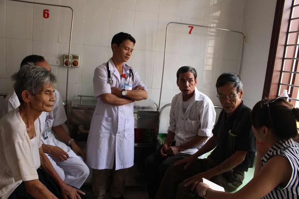 Y bác sĩ phòng khám đi “xin ăn” cho hàng chục bệnh nhân bị lũ cô lập - 2 Bác sĩ Hoàng (ở giữa) tới thăm hỏi các bệnh nhân bị mắc lũ còn ở lại điều trị.